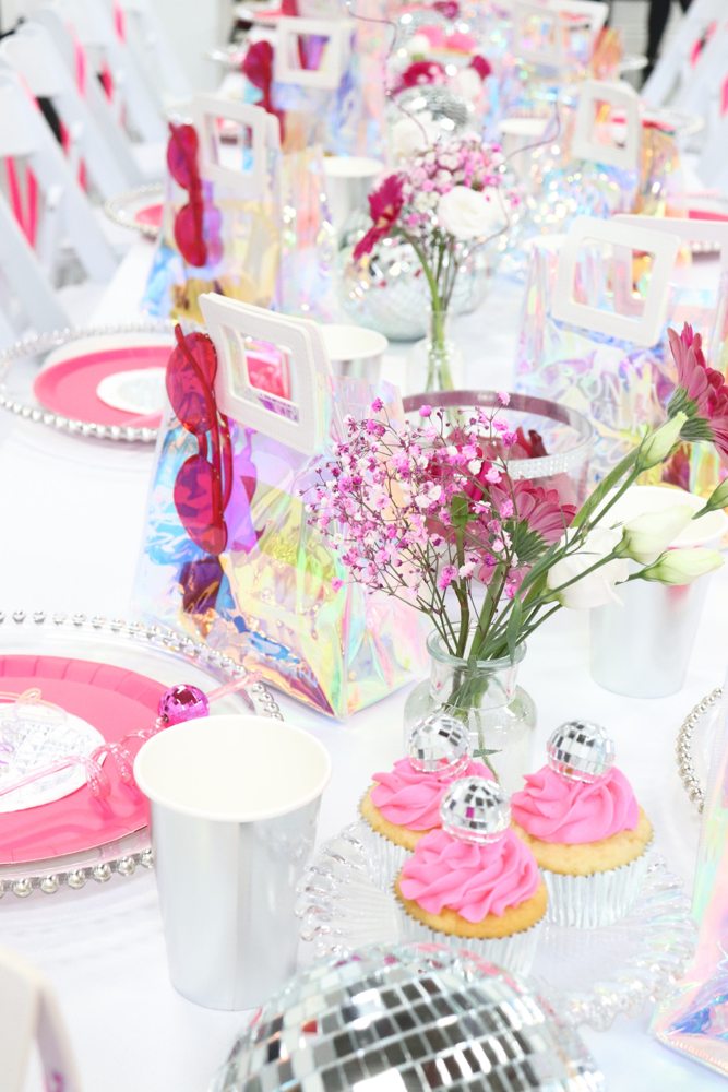 Pink party table with flowers and cupcakes